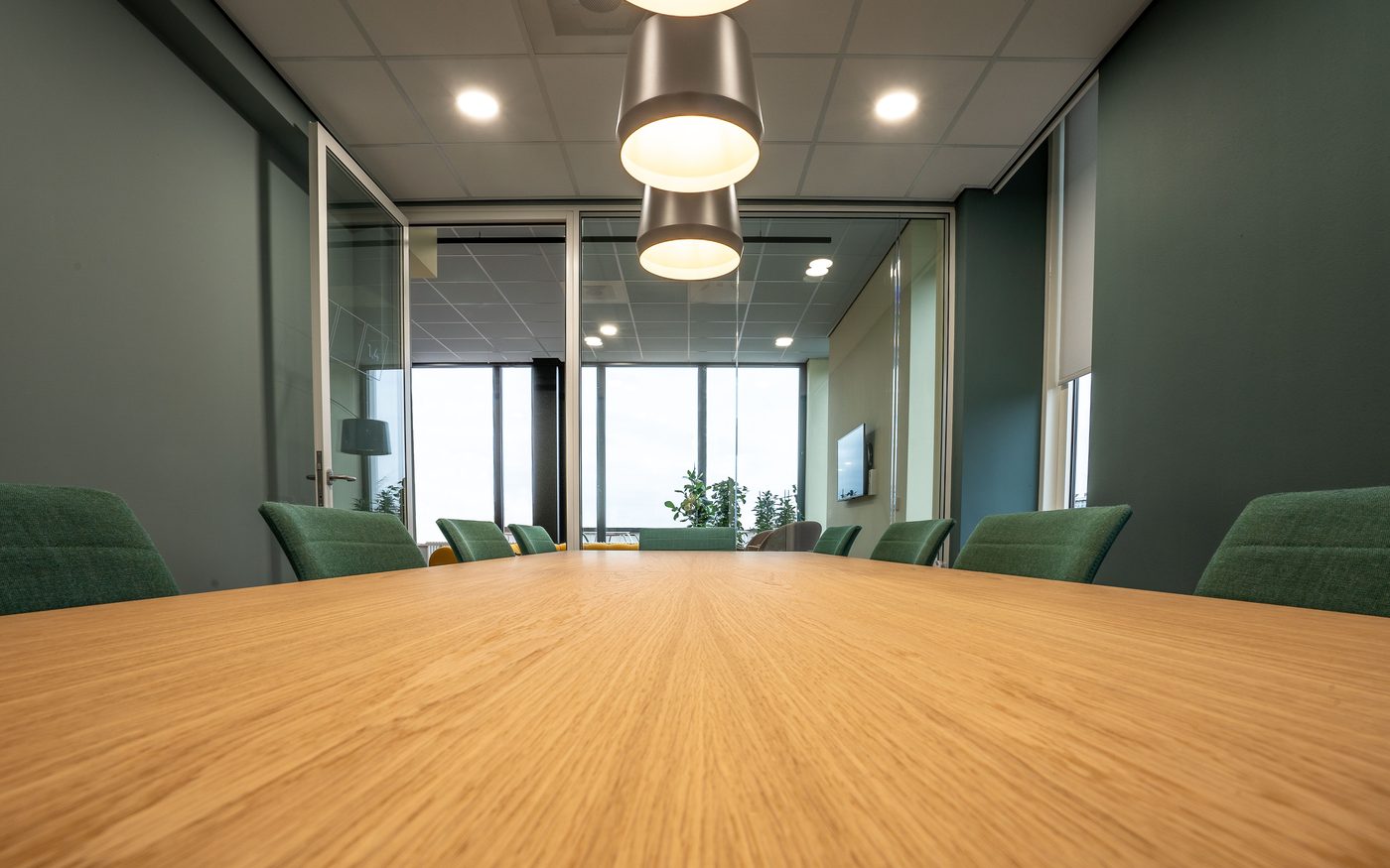 Boardroom with oak table, glazed partitions and pendant lighting